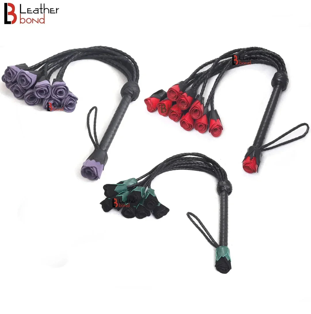 Three handmade leather floggers in purple, red, and green with rose-shaped tips.