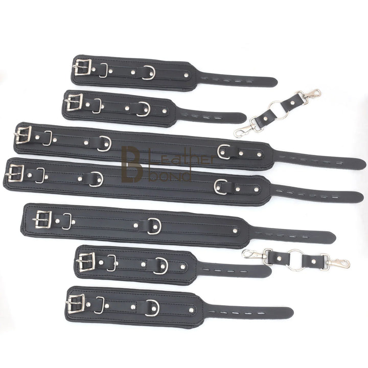 Close-up of the leather restraints, showing the metal buckles and rings on these black bondage cuffs as part of a kinky gear set