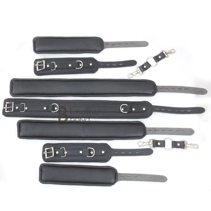 Underside view of the black leather bondage cuffs showing the plush padded lining for comfort, part of an adult restraint set for BDSM play.