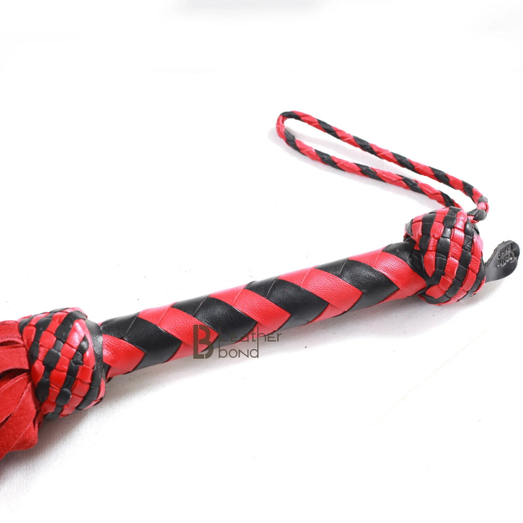 Braided leather handle and wrist loop of red and black leather flogger, offering control and grip during BDSM flogger spanking and flogger sex scenes.