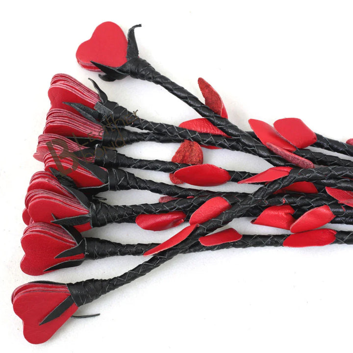 Close-up of braided leather flogger falls with red heart tips, a handcrafted BDSM flogger designed for impact play, flogger spanking, and flogger sex