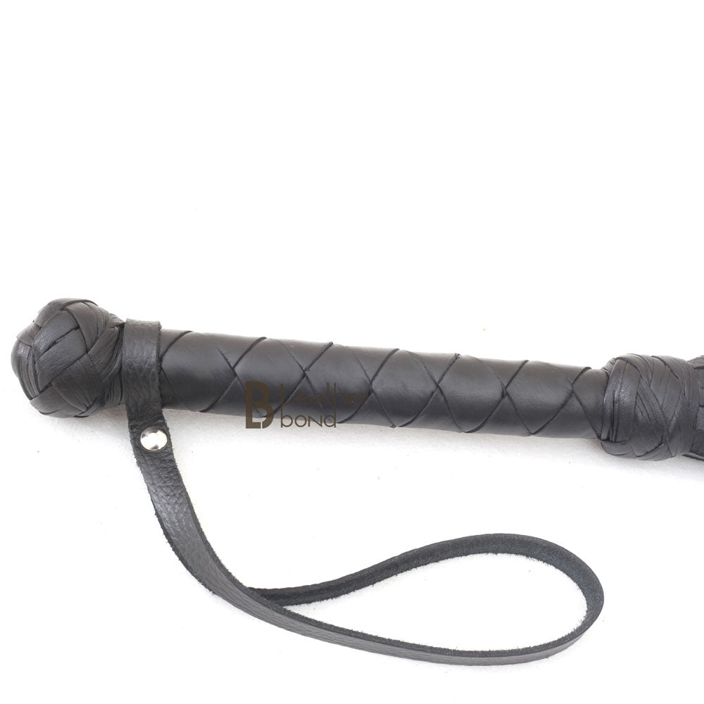 Braided leather handle with internal steel rod and wrist loop on a leather flogger whip for BDSM control and balanced flogger sex sessions.